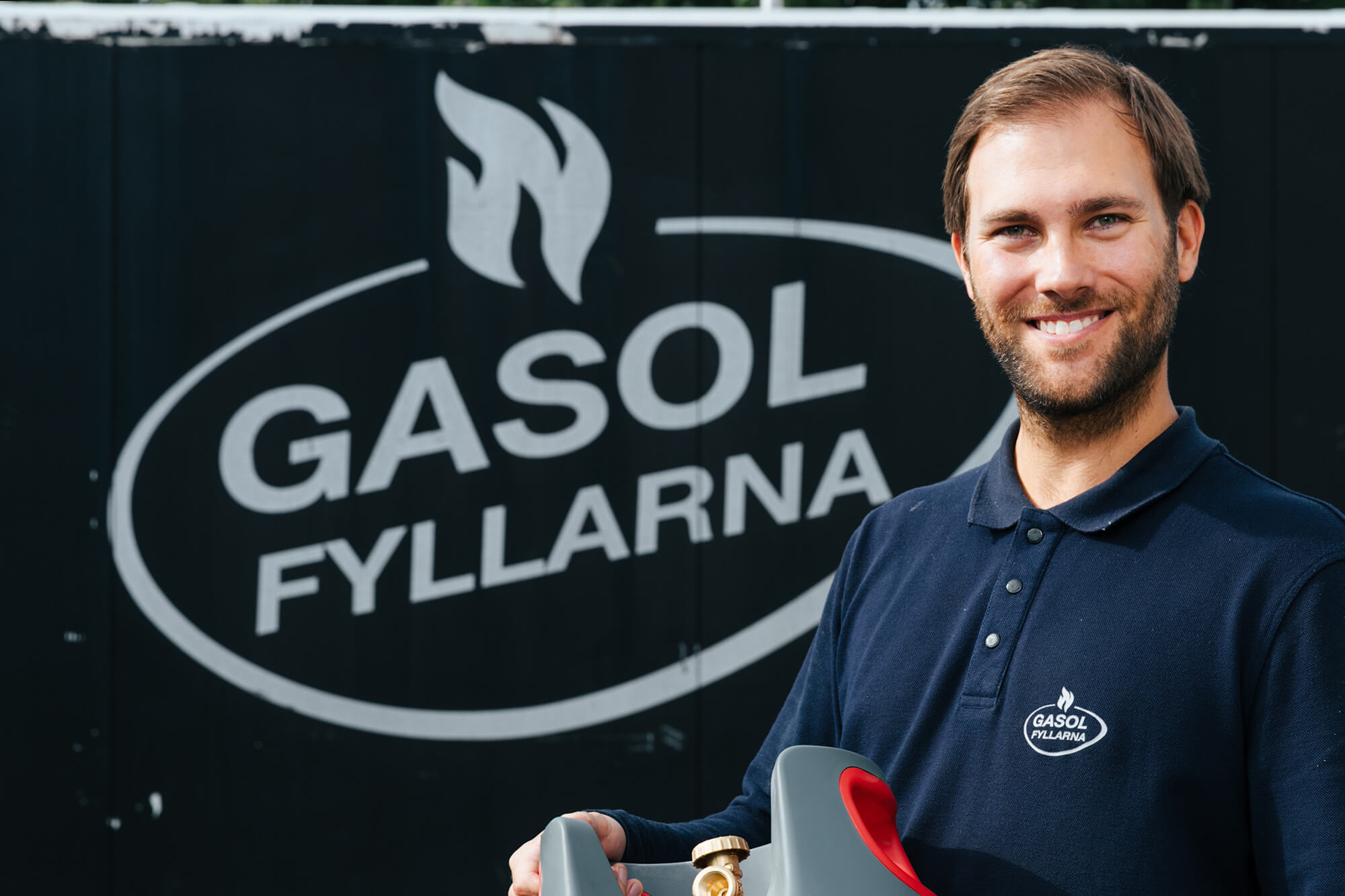 Man ler och håller i gasolflaska
