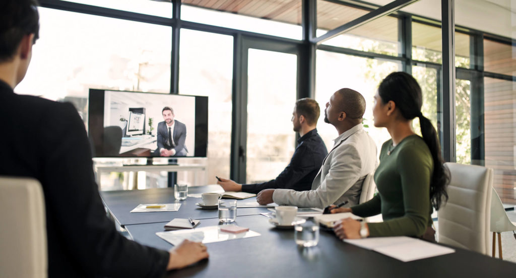 Persons around table watching TV