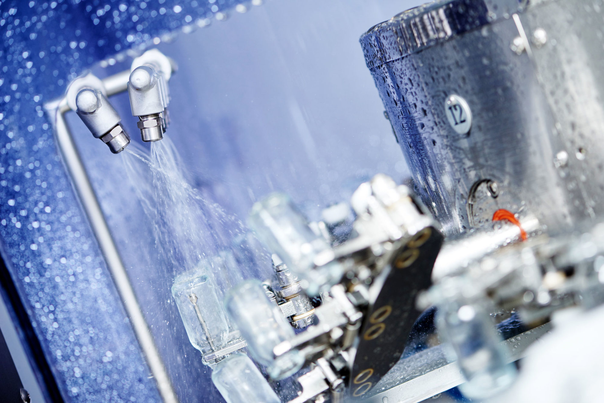 Produktion inom livsmedel, flaskor sköljs av med vatten.