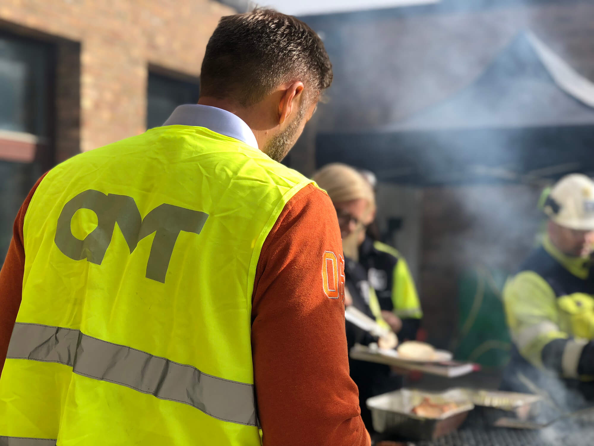 Personer i OMT-västar grillar